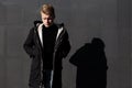 Young stylish redhead man in trendy outfit posing against urban background Royalty Free Stock Photo