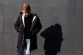 Young stylish redhead man in trendy outfit posing against urban background Royalty Free Stock Photo