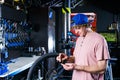 A young, stylish redheaded male small business owner selling and repairing a bike is wearing a blue cap and a pink jersey is using Royalty Free Stock Photo