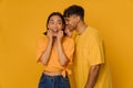 Young stylish smiling man whispering to beautiful enthusiastic asian woman Royalty Free Stock Photo