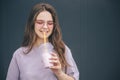 Young stylish trendy woman isolated over grey blue background. Attractive beautiful girl drinking milk cocktail through Royalty Free Stock Photo