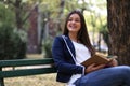 Young stylish woman in the city, sitting on a bench, reading a book. Royalty Free Stock Photo