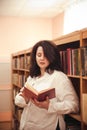 Portrait of young beautiful fashionable lady posing in library