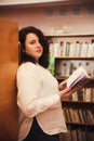 Portrait of young beautiful fashionable lady posing in library