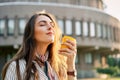 Young stylish woman in the street drinking morning coffee in sunshine light Royalty Free Stock Photo