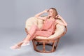 Young stylish woman with trendy shoes sitting in papasan chair Royalty Free Stock Photo