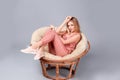 Young stylish woman with trendy shoes sitting in papasan chair Royalty Free Stock Photo