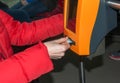 Young stylish woman using a ticket punching machine in public transport. The girl punches the ticket Royalty Free Stock Photo