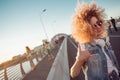 Young stylish woman with very lush hair show The Shaka Sign