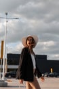 Young stylish woman in vintage hat in business fashionable clothes posing in city on sunny day. Beauty lady. Trendy elegant