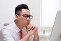 Young stylish worker at office working with computer and thinking how to solve difficult task