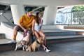 Young stylishly dressed man and woman with an athletic figure with two american bully dogs under the bridge on city Royalty Free Stock Photo