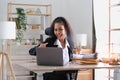 Young success american businesswoman raising her hands up and laughing with happiness at office Royalty Free Stock Photo