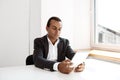 Young successful african businessman looking at tablet, sitting workplace. Royalty Free Stock Photo