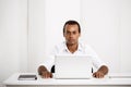 Young successful african businessman sitting at workplace with laptop. Royalty Free Stock Photo