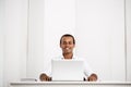 Young successful african businessman smiling, sitting at workplace with laptop. Royalty Free Stock Photo