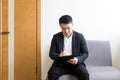 Young successful Asian man, waiting for a job interview, in the waiting room of the office center, sitting on a chair near the Royalty Free Stock Photo