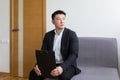 Young successful Asian man, waiting for a job interview, in the waiting room of the office center, sitting on a chair near the Royalty Free Stock Photo