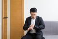 Young successful Asian man, waiting for a job interview, in the waiting room of the office center, sitting on a chair near the Royalty Free Stock Photo