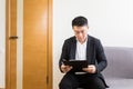 Young successful Asian man, waiting for a job interview, in the waiting room of the office center, sitting on a chair Royalty Free Stock Photo