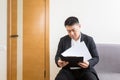 Young successful Asian man, waiting for a job interview, in the waiting room of the office center, sitting on a chair Royalty Free Stock Photo