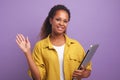 Young African American woman freelancer waving hand and holding laptop Royalty Free Stock Photo