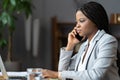 African woman e-commerce business owner talking on mobile phone, running online store from home Royalty Free Stock Photo