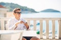 Young successful business man enjoying espresso coffee beverage in sunny marine panoramic cafe. Royalty Free Stock Photo