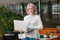 Young successful business woman programmer holding laptop and standing in office. Looking at camera Royalty Free Stock Photo