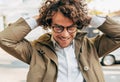 A young successful businessman in eyewear smiling broadly posing outdoors. Male entrepreneur resting in the city street. Smart guy Royalty Free Stock Photo