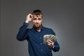 Young successful businessman holding money over dark background. Copy space. Royalty Free Stock Photo