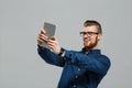 Young successful businessman looking at tablet over grey background. Royalty Free Stock Photo