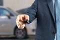 Young successful businessman offering a car key. Royalty Free Stock Photo