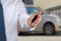 Young successful businessman offering a car key. Close-up of dri Royalty Free Stock Photo