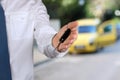 Young successful businessman offering a car key. Close-up of driver's hand showing key Royalty Free Stock Photo