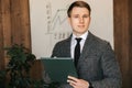 Young successful businessman and office worker holds a folder with documents in his hands makes notes on paper Royalty Free Stock Photo