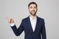 Young successful businessman pointing direction with finger over dark grey background. Copy space. Royalty Free Stock Photo