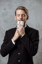 Young successful businessman in suit holding money over grey background. Royalty Free Stock Photo