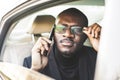 Young successful businessman talking on the phone sitting in the backseat of a expensive car. Negotiations and business Royalty Free Stock Photo