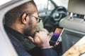 Young successful businessman talking on the phone sitting in the backseat of a expensive car. Negotiations and business Royalty Free Stock Photo