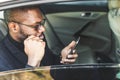 Young successful businessman talking on the phone sitting in the backseat of a expensive car. Negotiations and business Royalty Free Stock Photo