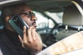 Young successful businessman talking on the phone sitting in the backseat of a expensive car. Negotiations and business Royalty Free Stock Photo