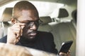 Young successful businessman talking on the phone sitting in the backseat of a expensive car. Negotiations and business Royalty Free Stock Photo