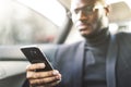 Young successful businessman talking on the phone sitting in the backseat of a expensive car. Negotiations and business Royalty Free Stock Photo