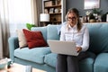 Young successful businesswoman working on laptop computer from home office. Business female finishing her work while sitting on Royalty Free Stock Photo