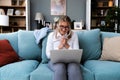 Young successful businesswoman working on laptop computer from home office. Business female finishing her work while sitting on Royalty Free Stock Photo