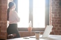 Young woman looking out window in office Royalty Free Stock Photo