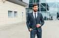 Young and successful. Handsome young man in full suit adjusting his jacket while standing outdoors Royalty Free Stock Photo