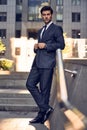 Young and successful. Handsome young man in full suit adjusting his jacket while standing outdoors Royalty Free Stock Photo