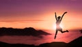 Young Successful Happy Woman Jumps For Joy On The Top of Mountain Peak Above Clouds At Sunset Royalty Free Stock Photo